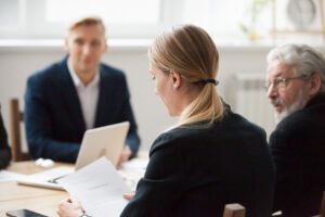 focused serious businesswoman reading document at group meeting